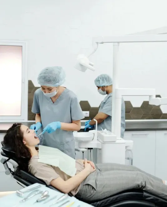 Dental professionals providing care to a patient seated comfortably in a modern dental clinic.