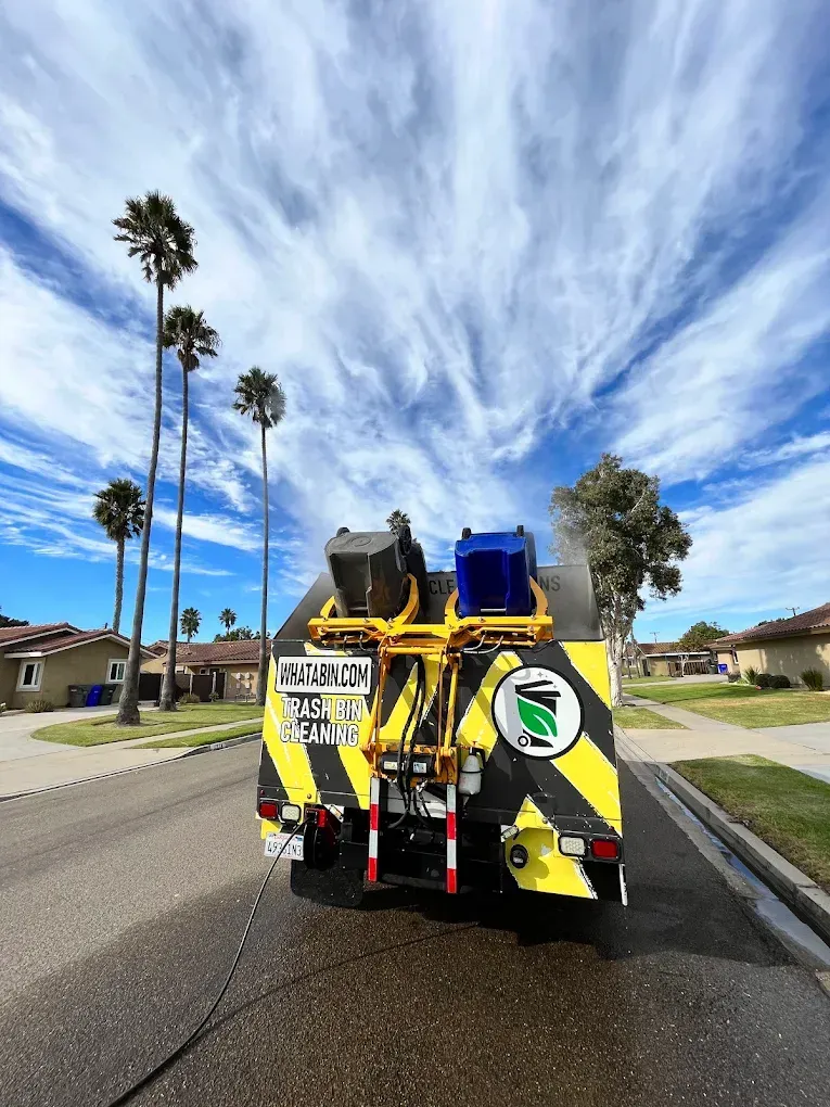 What A Bin truck cleaning trash and recycle bins with a self-contained hot steam cleaning unit on a sunny residential street in San Diego, California.
