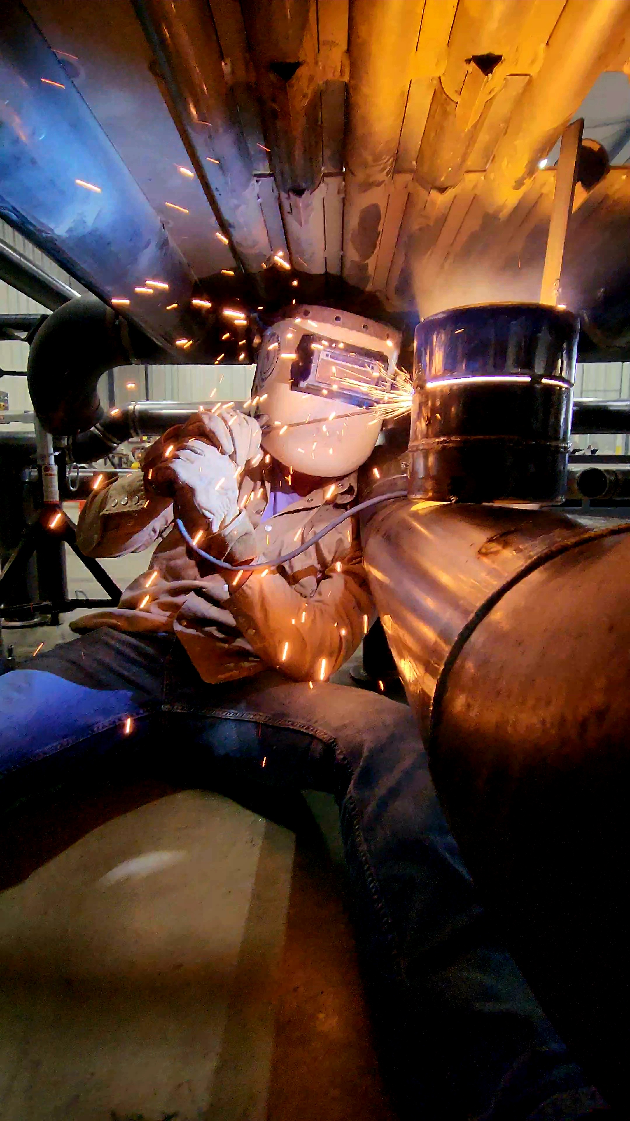 Person welding metal with bright sparks flying.