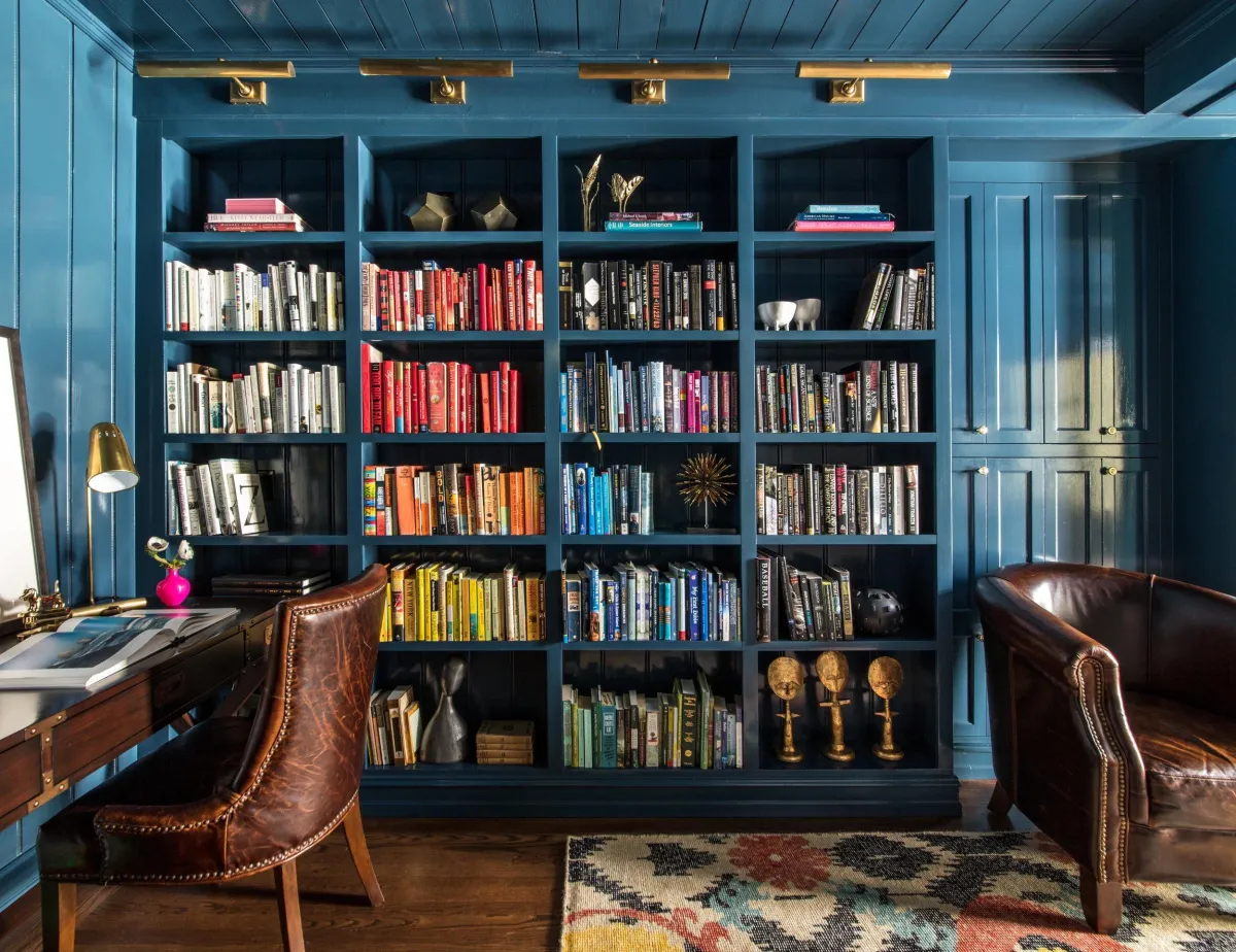 beautiful interior design library floor to ceiling shelves books lined up in rainbow colors old leather chairs brass light fixtures interior design photography by photographer thomas kuoh