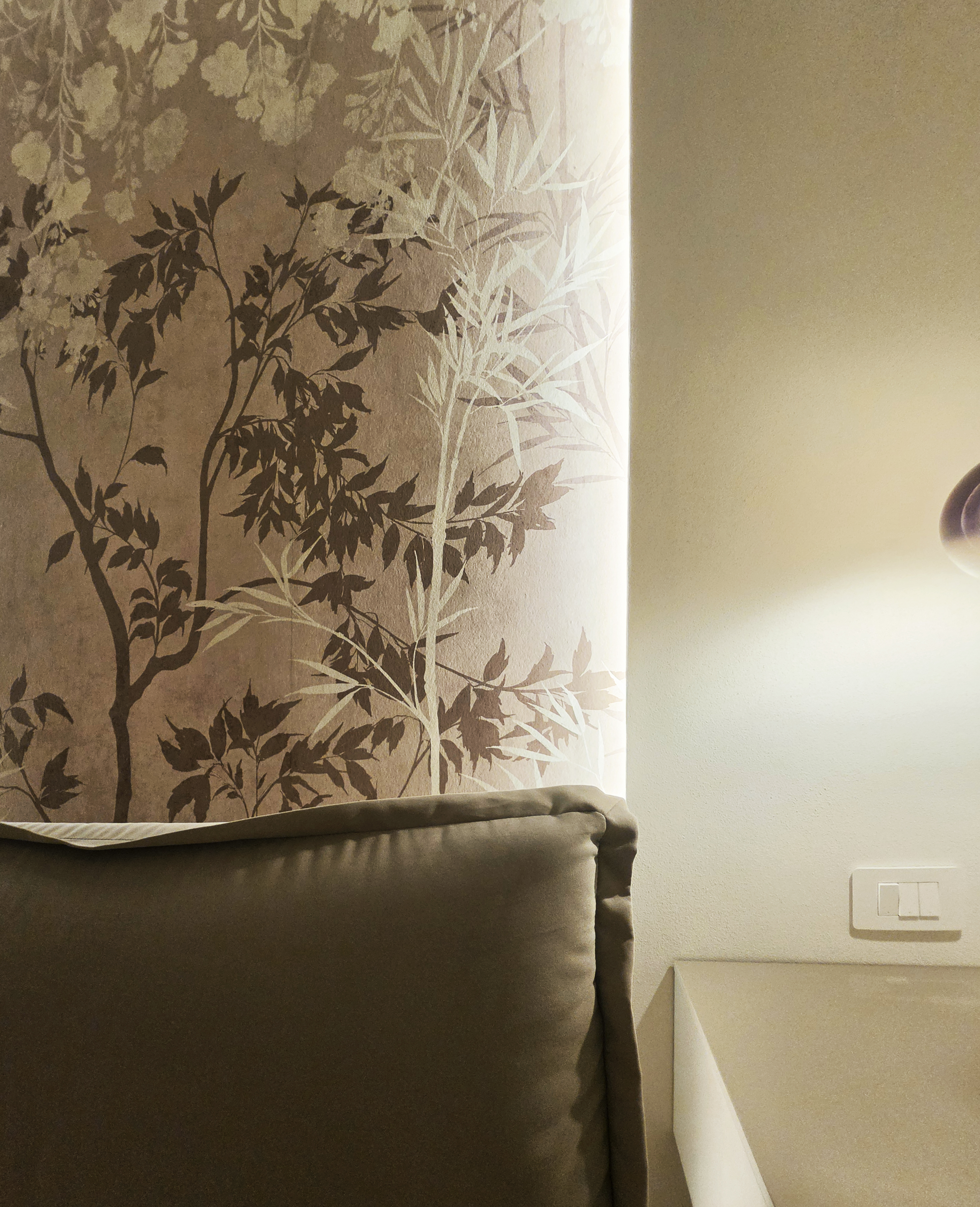 Parete della camera con motivi vegetali decorativi in tonalità neutre