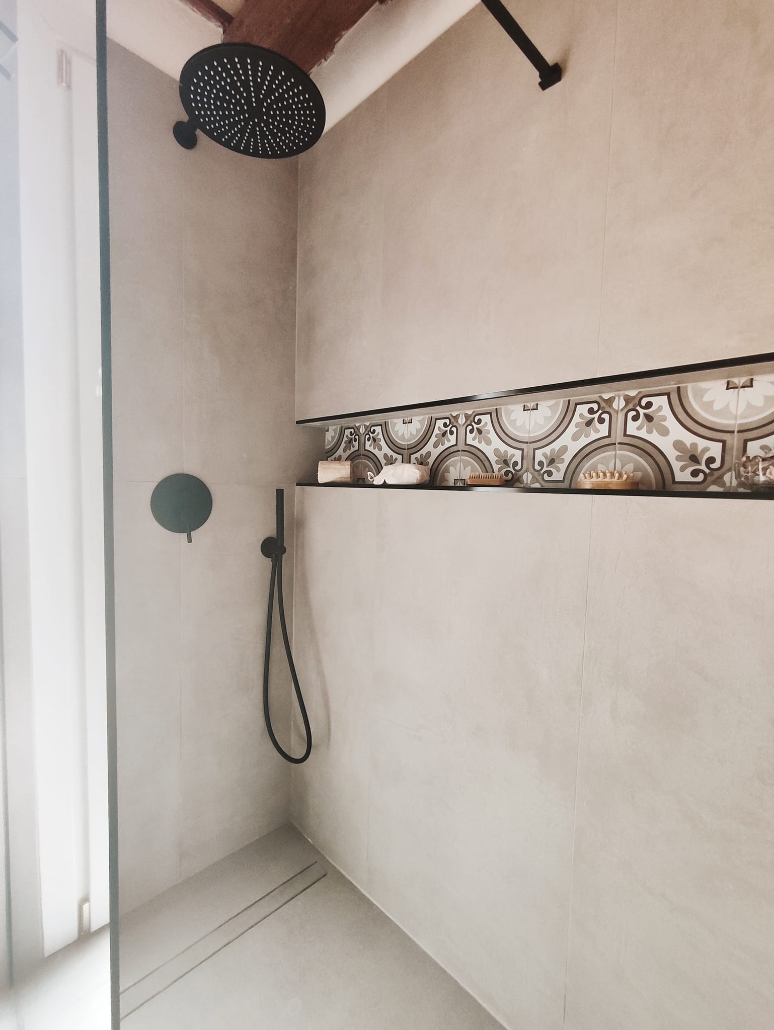 Doccia con ceramica decorata artigianale e calce nei toni caldi, dettaglio di artigianato siciliano