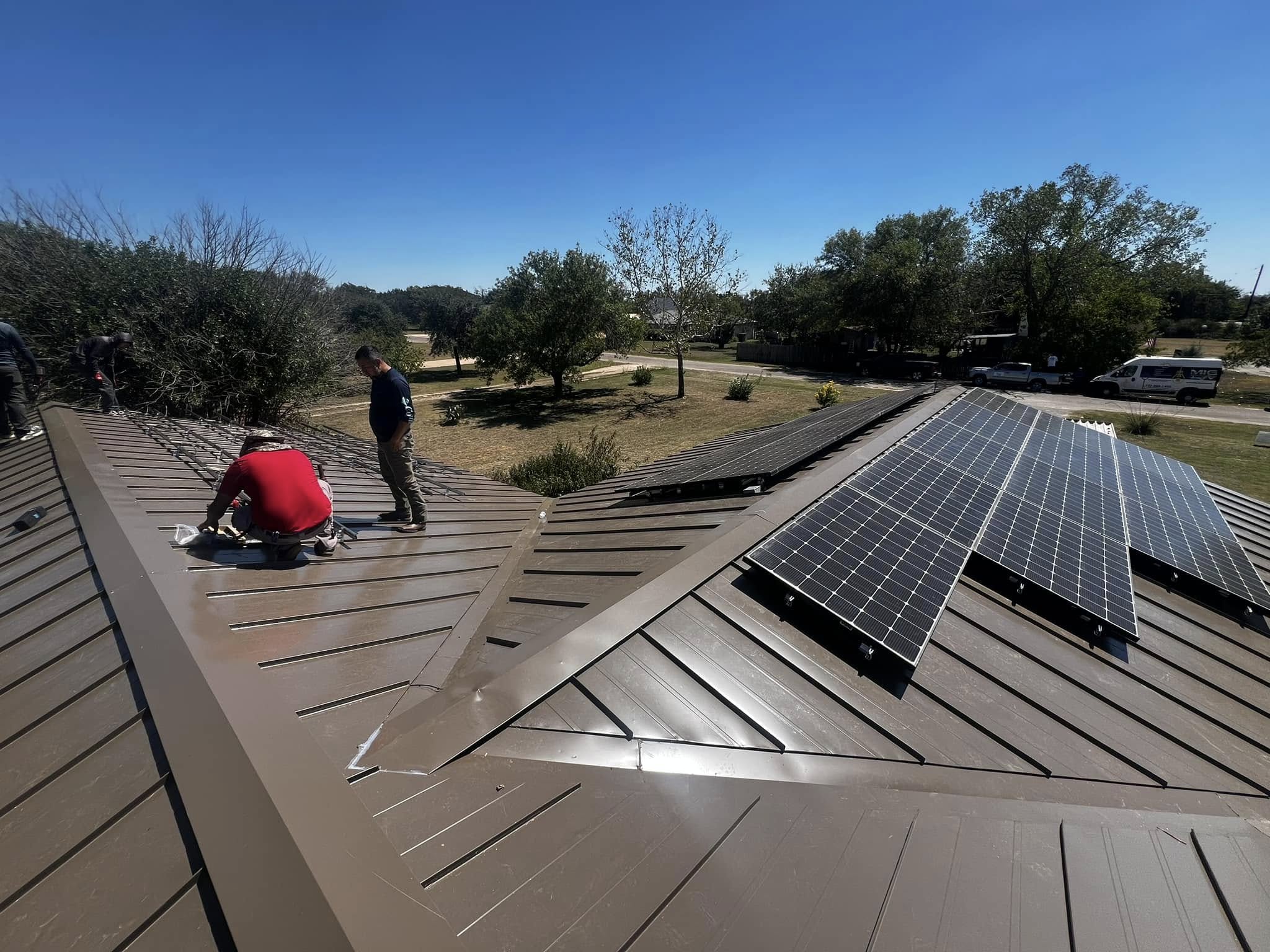 Crew mounting solar panels on residential metal roof, Central Texas