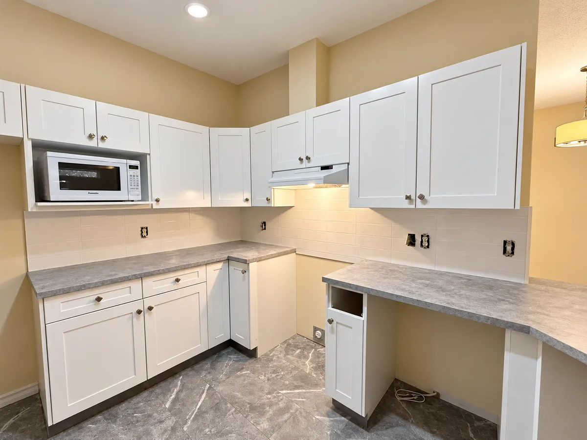 Kitchen remodeling with white cabinets and new countertops in Calgary
