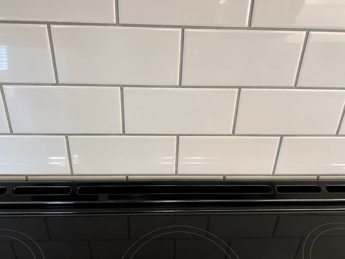 Close-up of white subway tile backsplash installation in Calgary