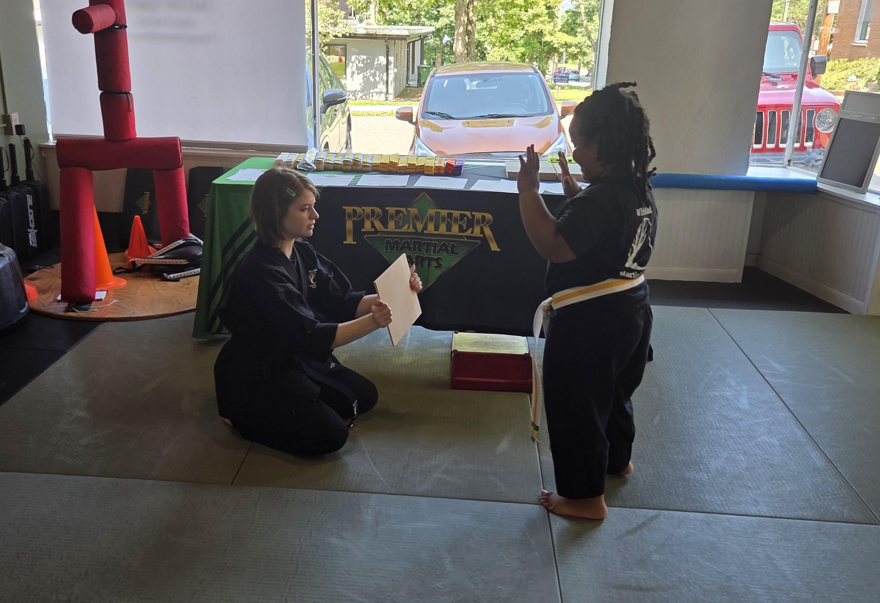 Instructor helping young student with martial arts technique