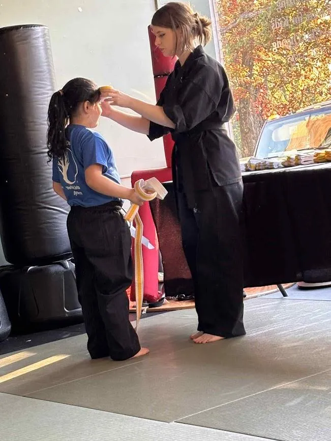 Kids martial arts class practicing together in uniform