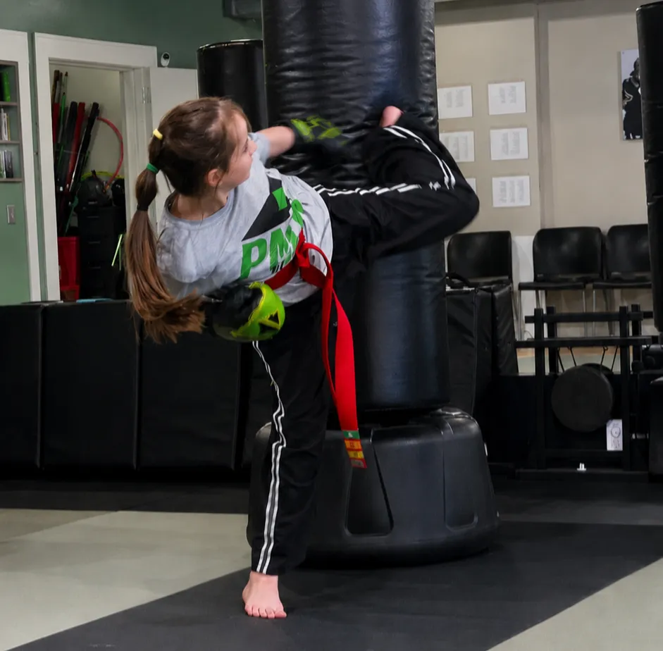 Instructor helping young student with martial arts technique