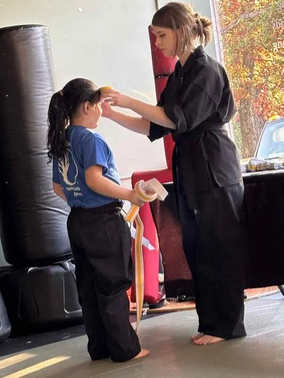 Kids martial arts class practicing together in uniform