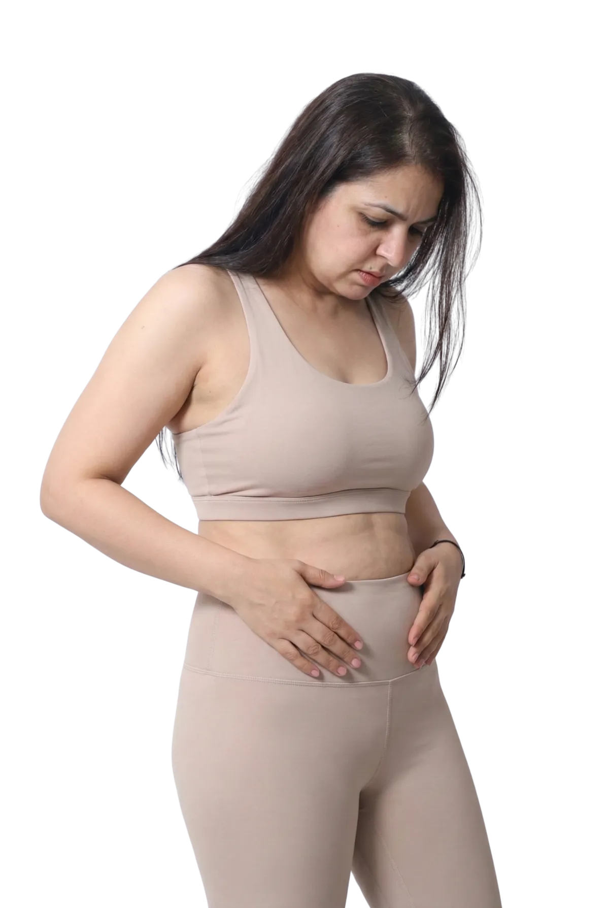 A woman in her forties looking down at her belly