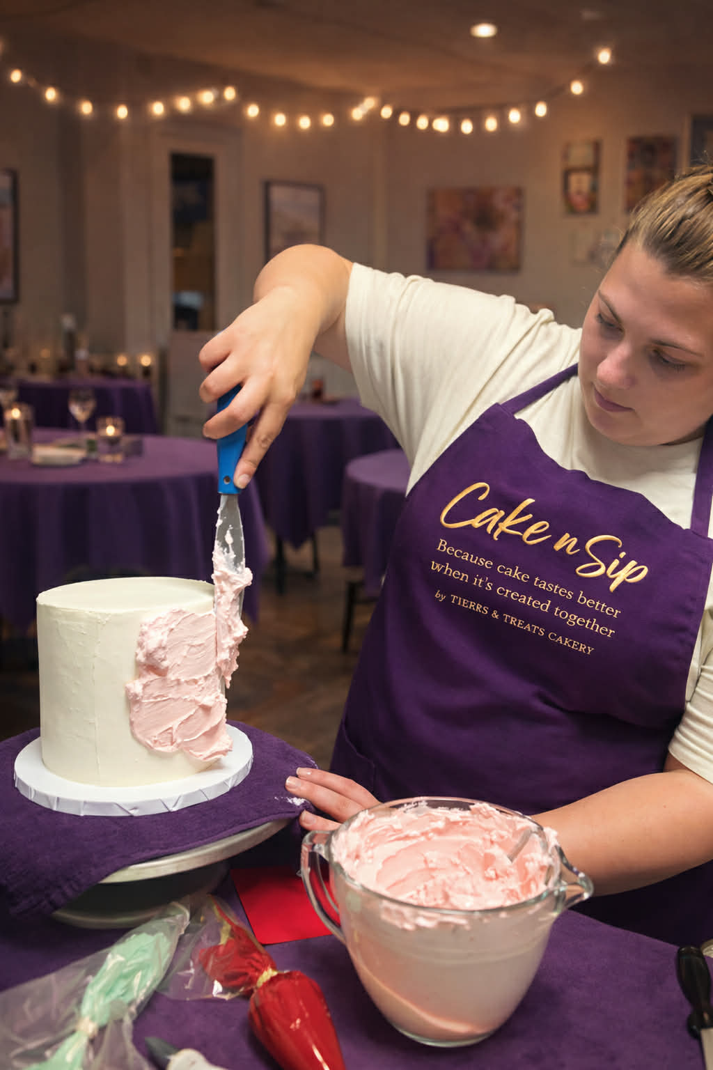 Guests smiling while decorating cakes at a Cake n Sip event