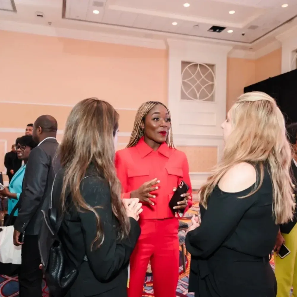 Dr. Ogo Ekwueme in a red suit talking with attendees at a Career Haven event