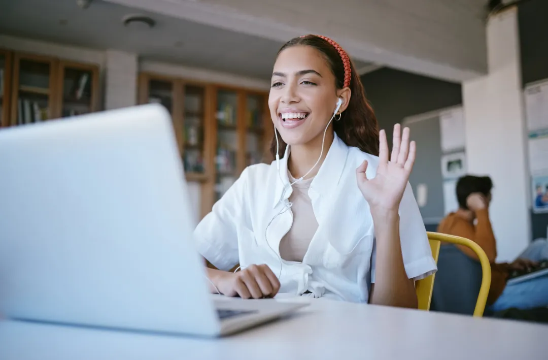 Person waving at a laptop, representing a Resonate with People Locally member