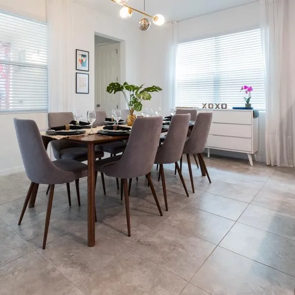 Large galley kitchen with island, stainless steel appliances, granite countertops, spice rack, and knife block with dining area in background