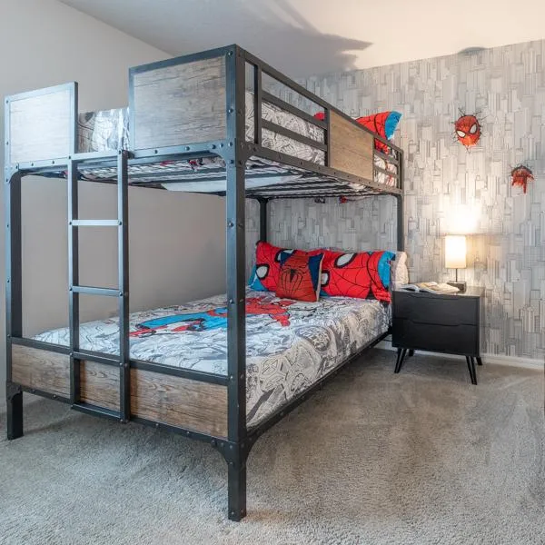 Spiderman theme bedroom with full sized bunk bed, nightstand, and USB charging lamp. A 3d will scuplure of Spiderman's head and hand hang on the wall.