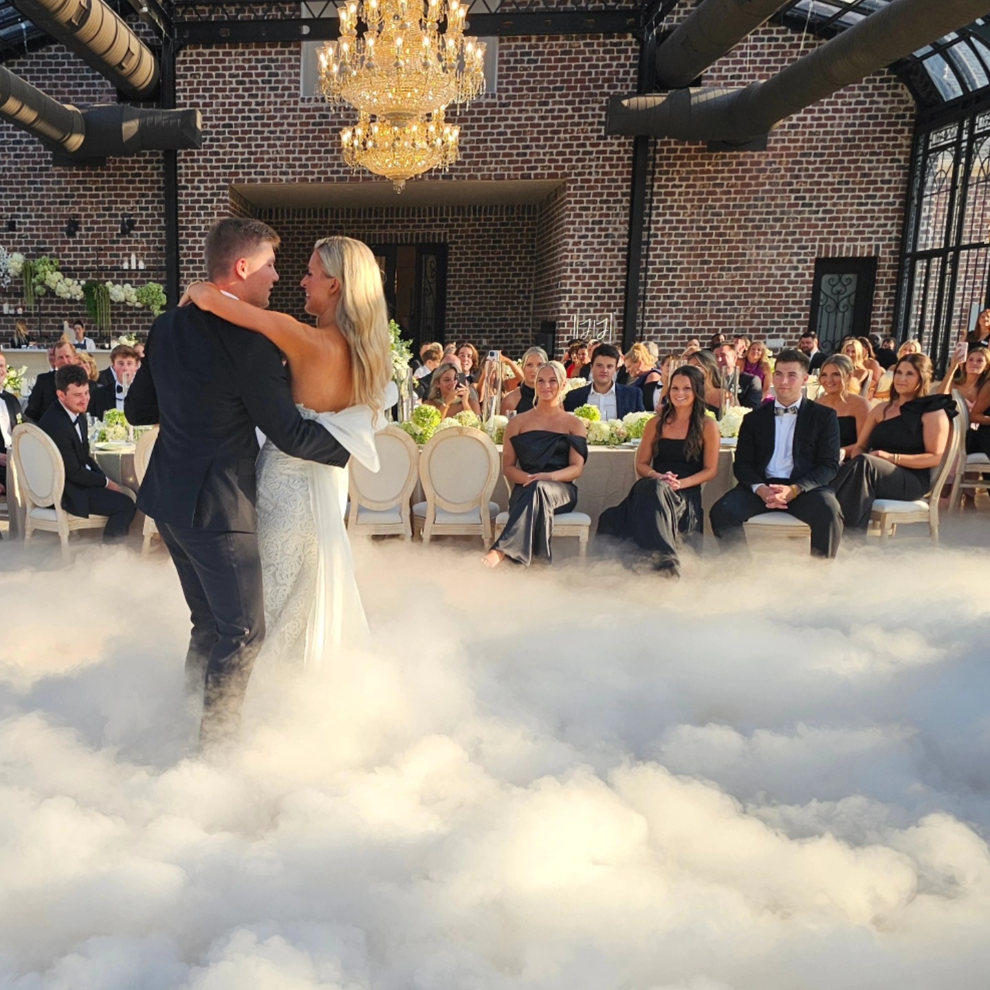 Elegant wedding reception with packed dance floor and warm lighting