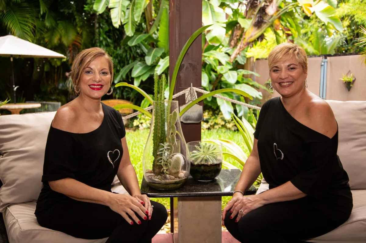One-on-one coaching session between two adult women (coach and client), warm candid supportive moment, soft warm lighting, close-to-medium framing, professional and uplifting tone