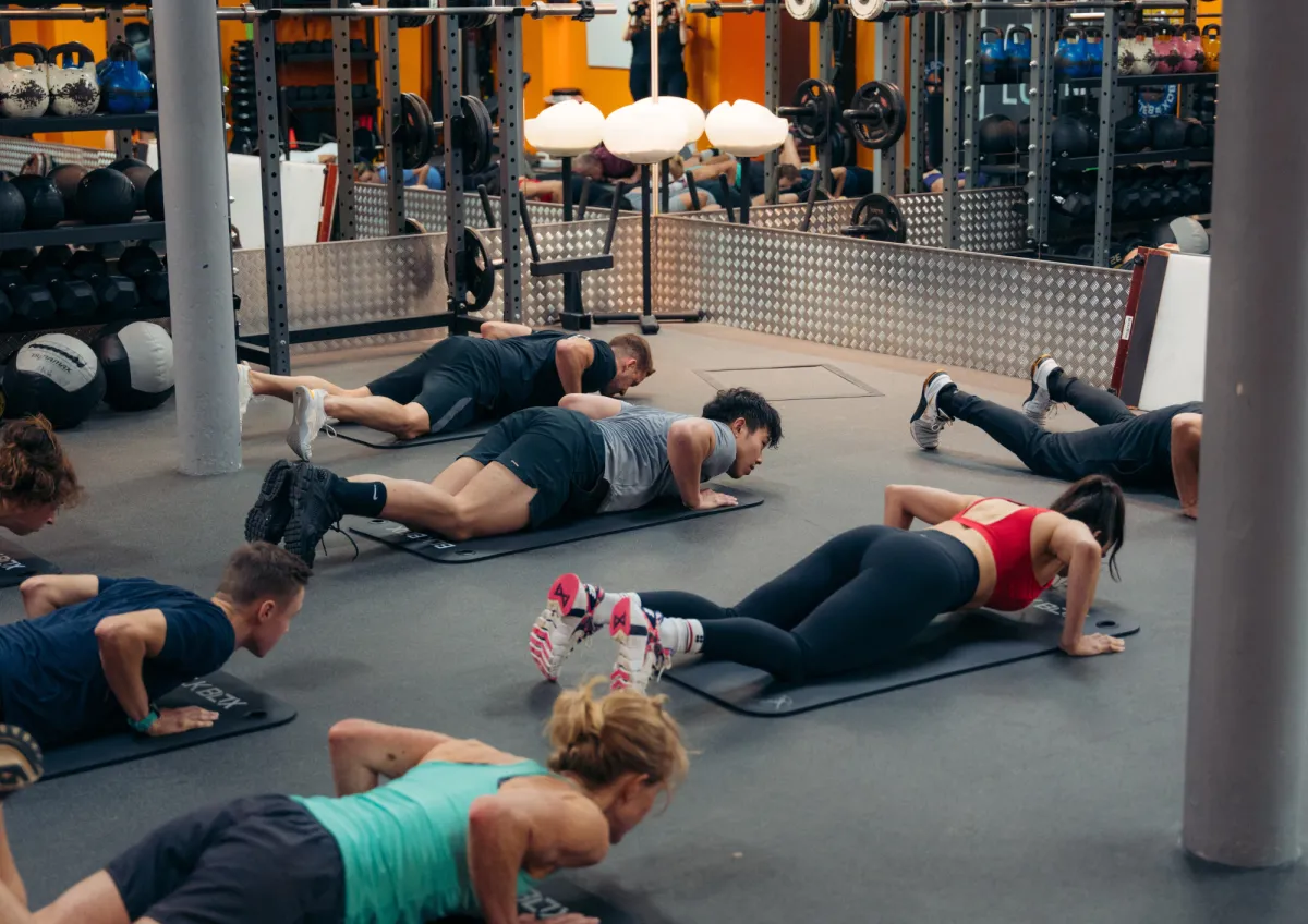 man in black long sleeve shirt and black pants carrying black dumbbell