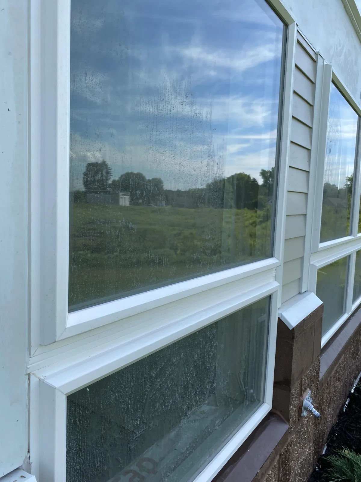 Dirty residential windows with water spots and grime before professional window cleaning service