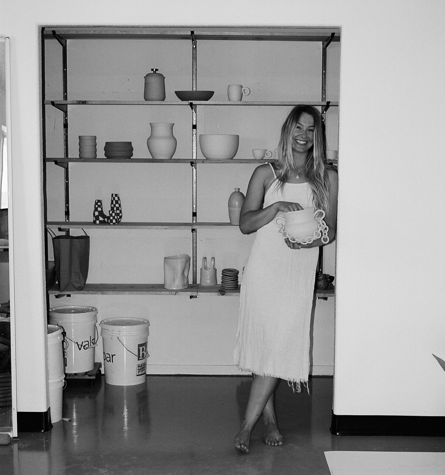 Hands shaping a clay leaf on parchment paper