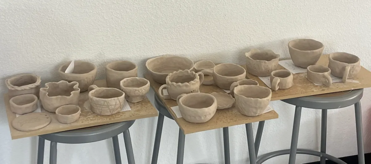 Ornate ceramic plates and vase displayed on brick wall.
