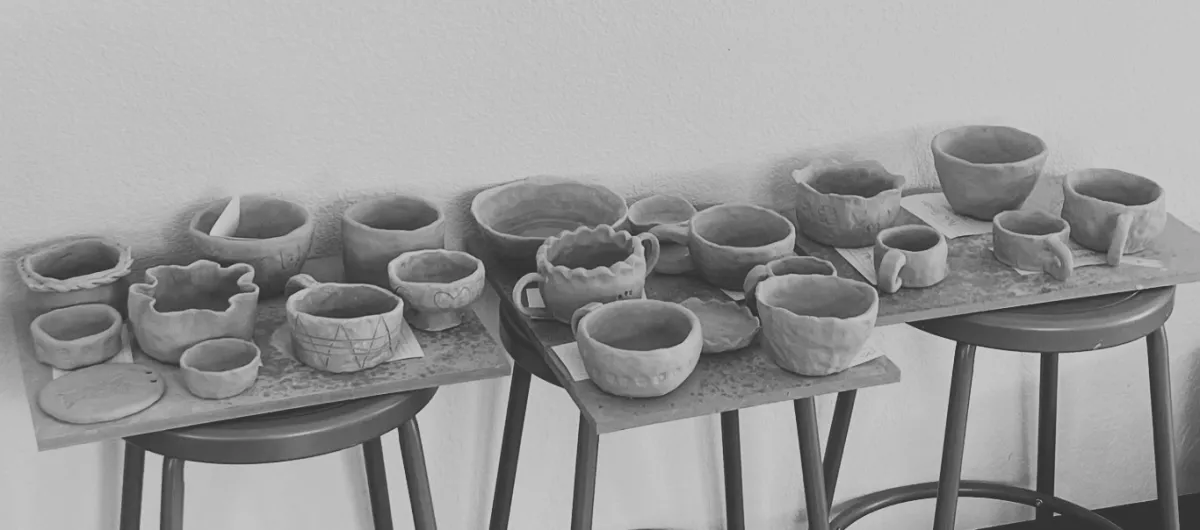 Ornate ceramic plates and vase displayed on brick wall.