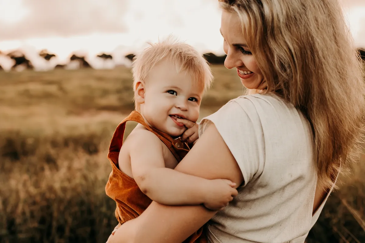 Calm, authentic portrait of a reflective mother in warm natural light