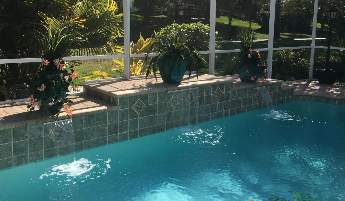 Outdoor artificial plants, ferns and flowers in planters around pool