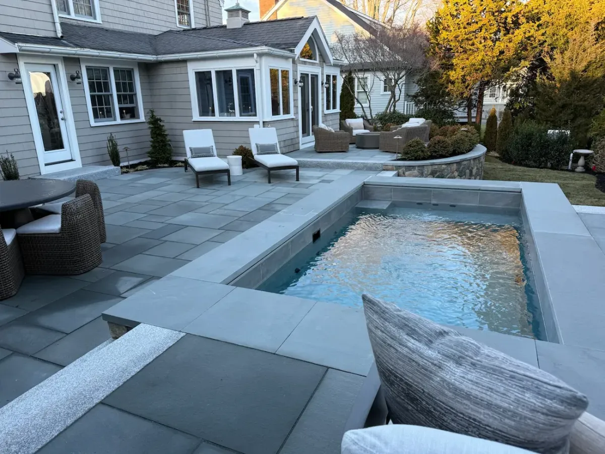 Custom water feature and bluestone patio designed for a residential landscape in Marblehead, MA