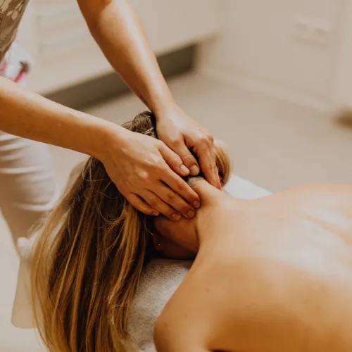 massage therapist massaging client face down.