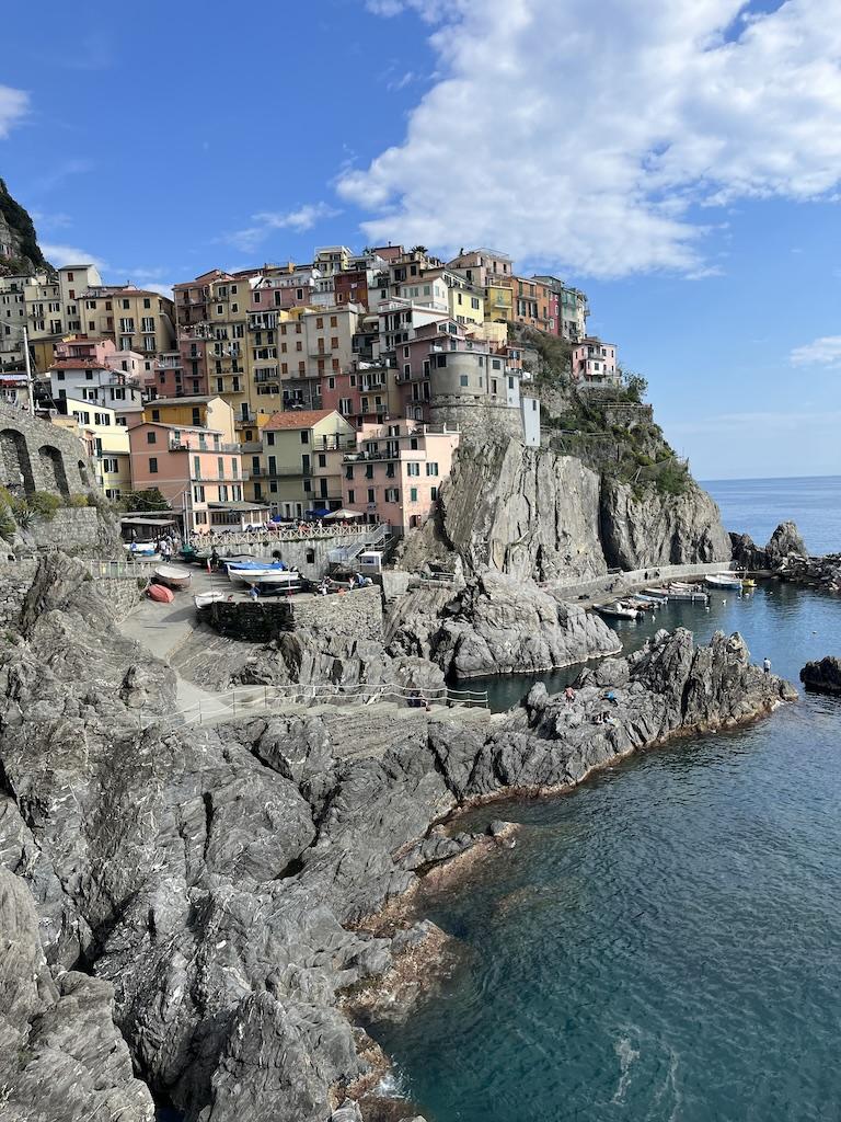 Colorful coastal village built into rocky cliffs, showcasing traditional European architecture by the sea