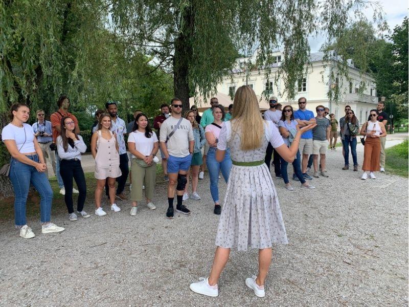 Young woman in traditional dirndl giving a private Sound of Music tour at a filming site in Austria