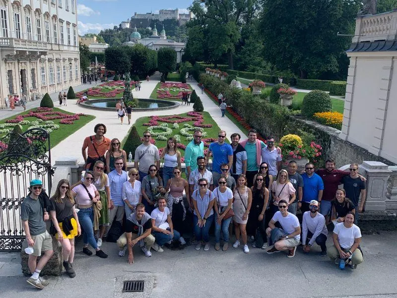 Group of travelers in front of a historic European monument during a custom group tour