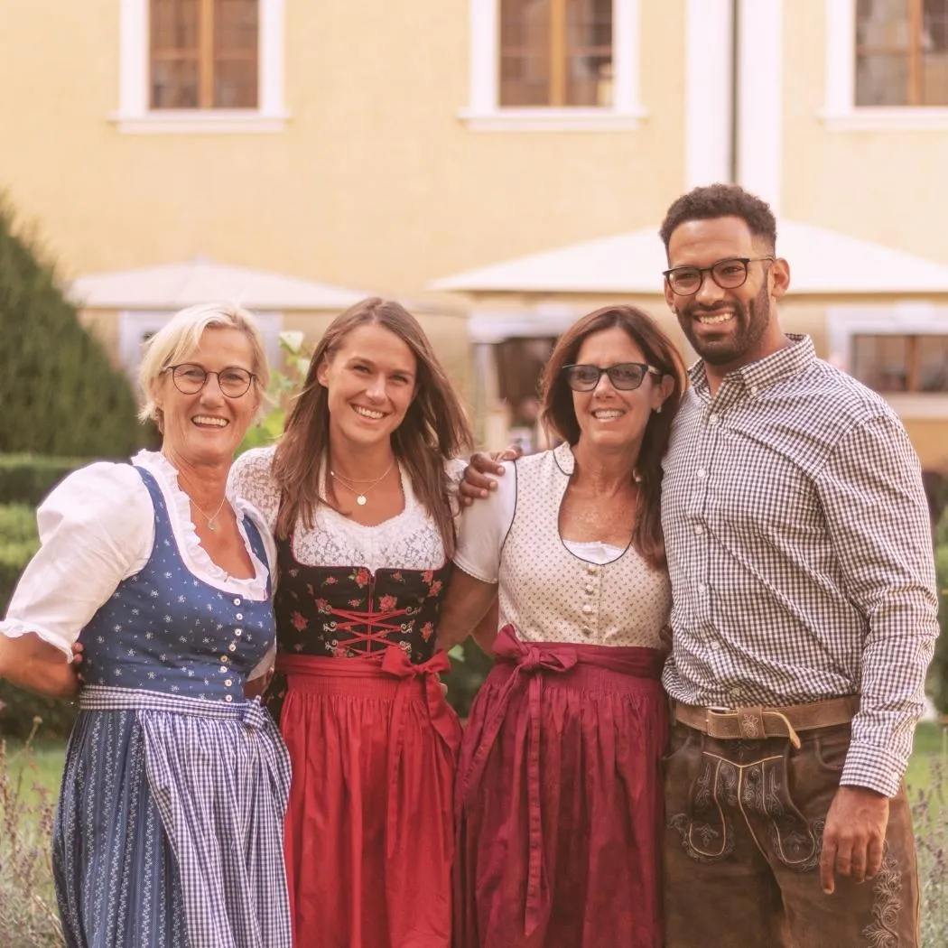 Four people wearing traditional Bavarian Tracht smiling at Oktoberfest celebration