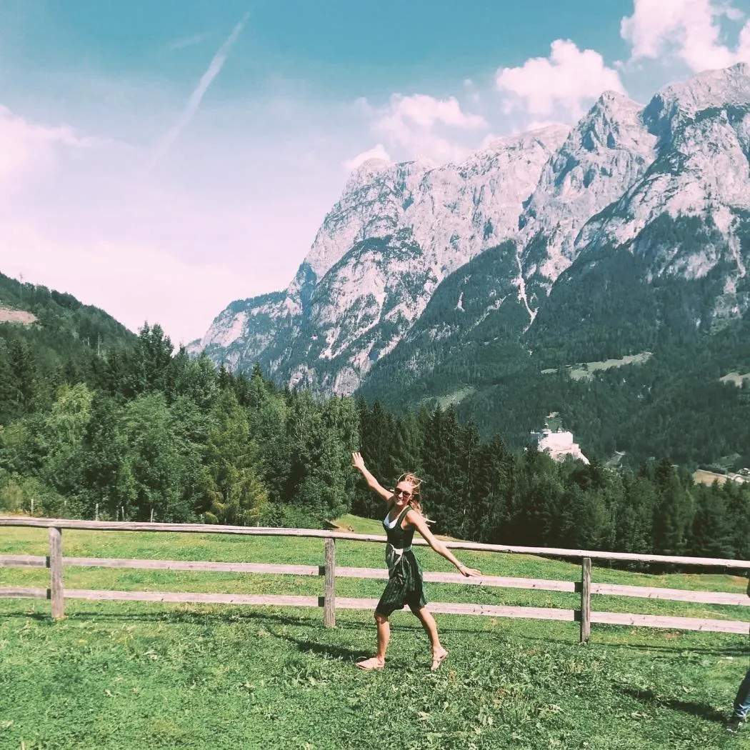 Girl in Austrian Dirndl dancing joyfully at iconic Sound of Music filming location in Salzburg