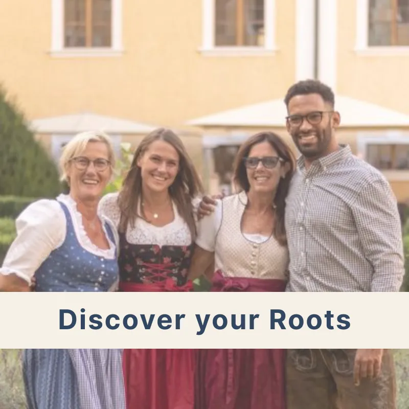 Four people, two young and two older, wearing traditional Dirndl and Tracht, enjoying a “Discover Your Roots” heritage experience in Austria or Germany.
