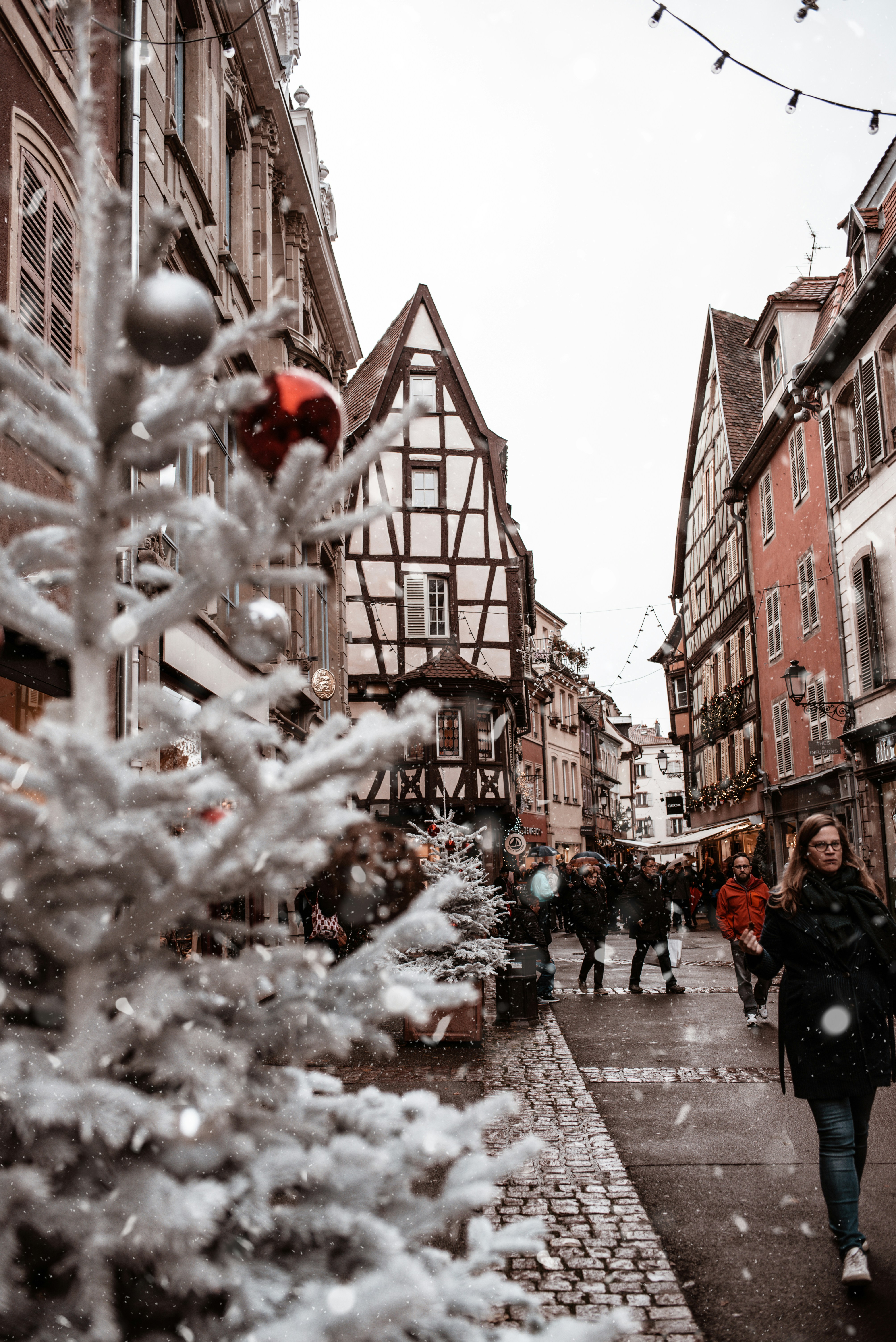 Festive street in Alsace with half-timbered houses decorated for Christmas in France