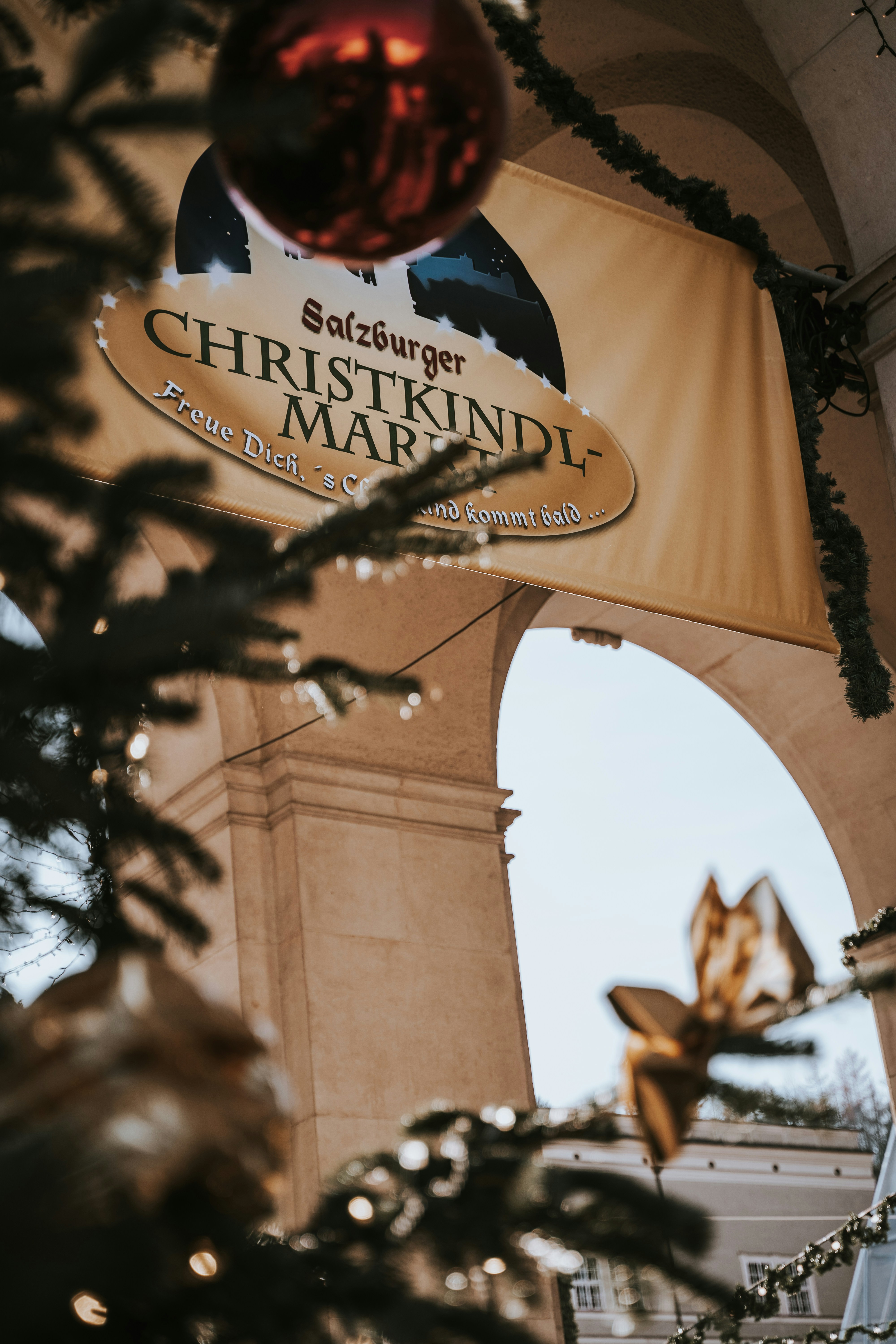 Stone arch entrance to Salzburg Christmas market with sign reading Salzburger Christkindlmarkt in Austria