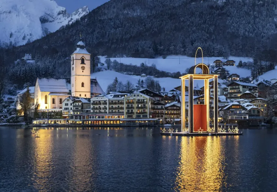 Wolfgangsee Advent Christmas market in Austria with glowing lantern on the lake, alpine village, and mountains at night