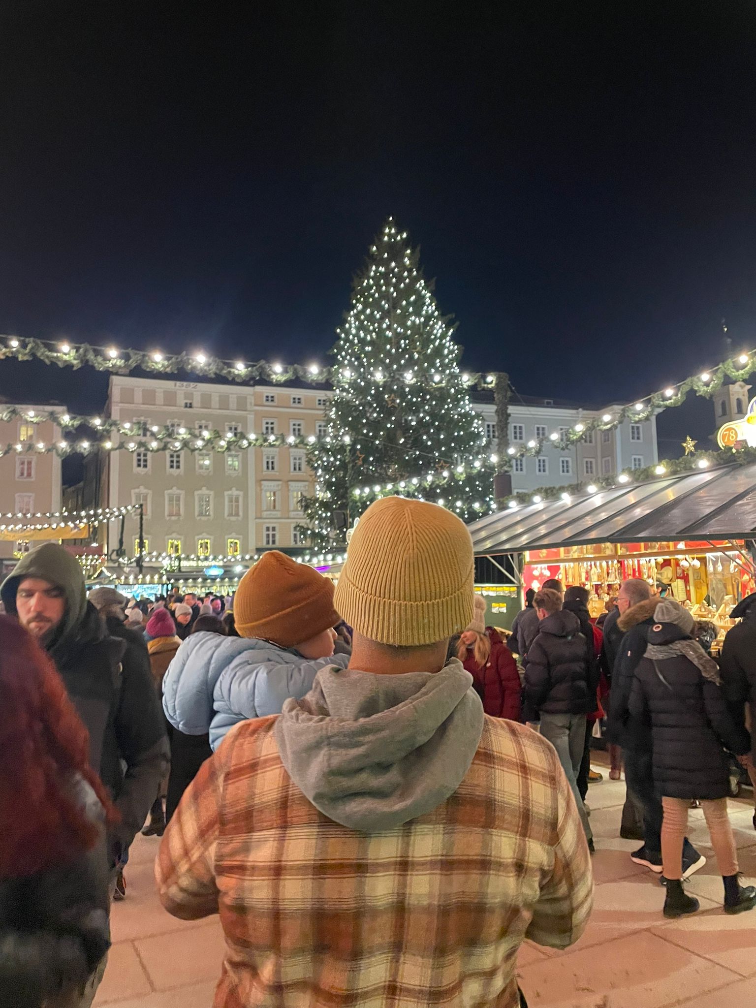 Salzburg Residenzplatz Christmas market with festive lights and people enjoying the atmosphere at night