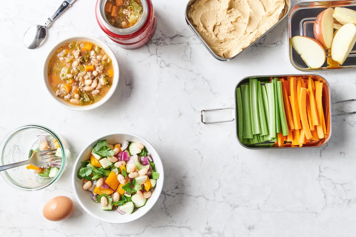Healthy soup, salad & vegetable recipes on a white marble surface