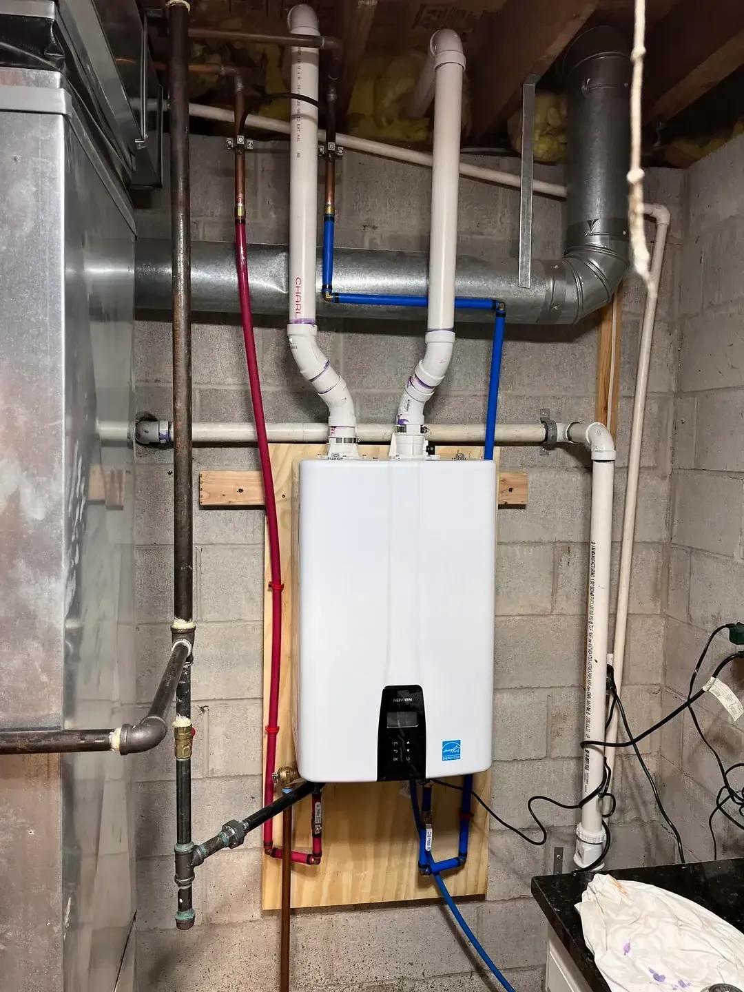  tankless water heater that was installed with an anergy  saving sticker on it within a residential clients basement hvac