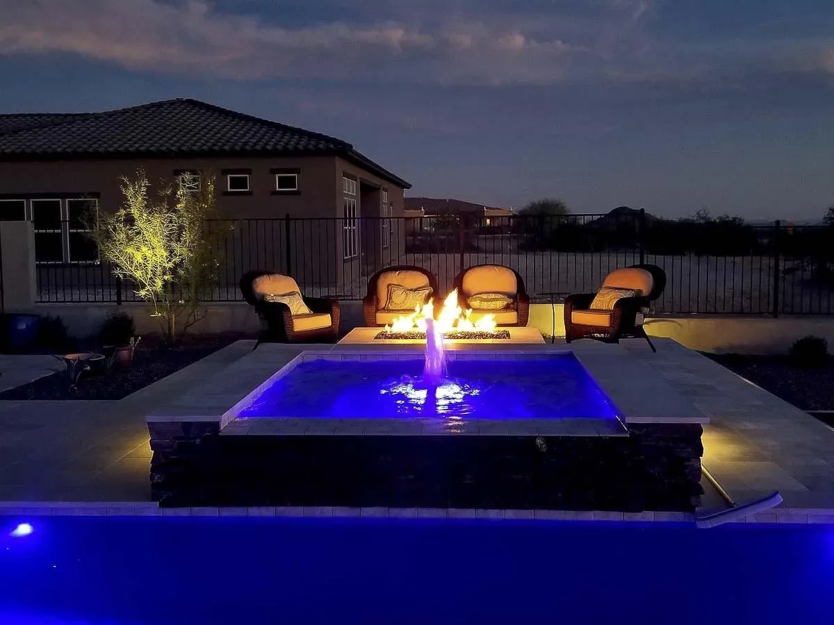 A large swimming pool next to a lush green hillside