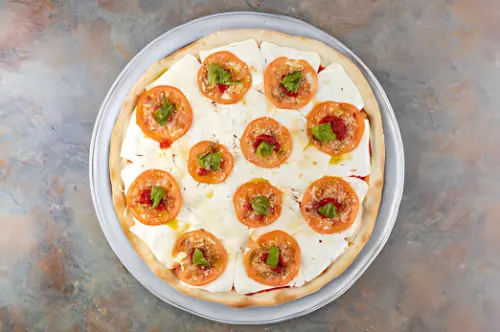 A close-up of a Margherita pizza with fresh basil leaves.