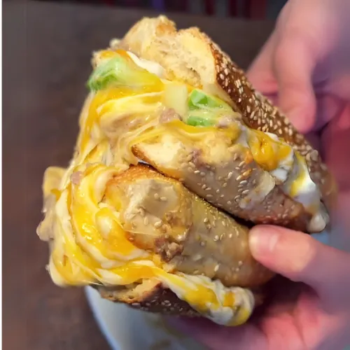 A juicy chicken burger paired with a side salad, served on a toasted bun with fresh veggies and condiments.