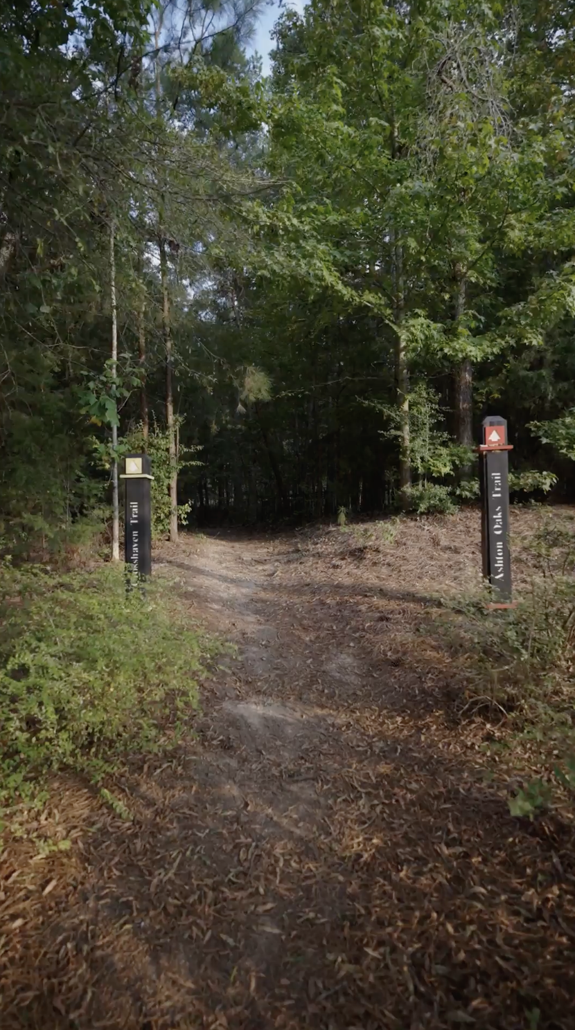 Wooded walking trail entrance at The Palisades community in Charlotte, North Carolina, providing access to neighborhood nature trails.