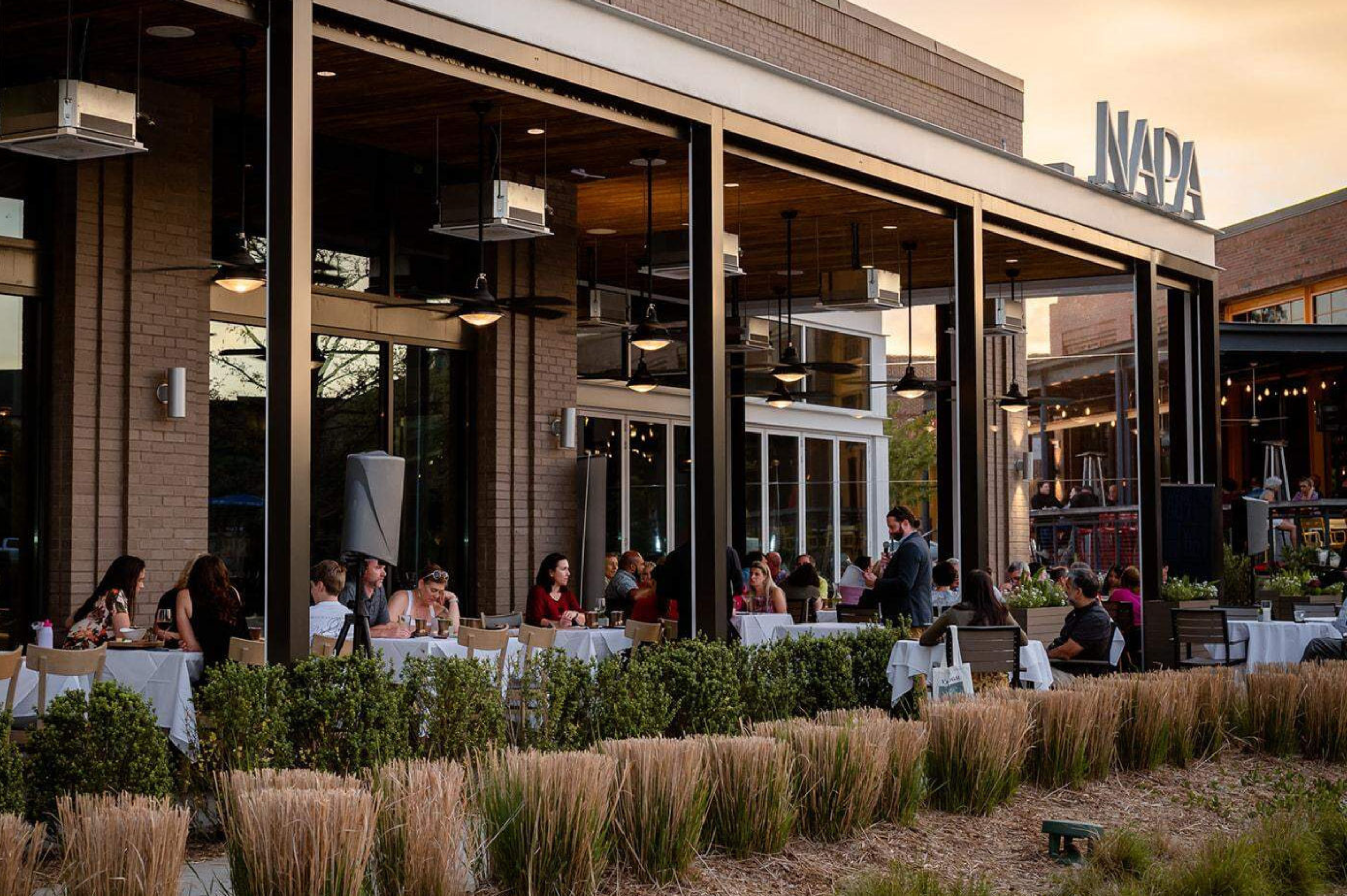 Outdoor patio dining at Napa at Kingsley in Fort Mill, featuring a modern California-inspired restaurant known for wine, brunch, and upscale American cuisine.