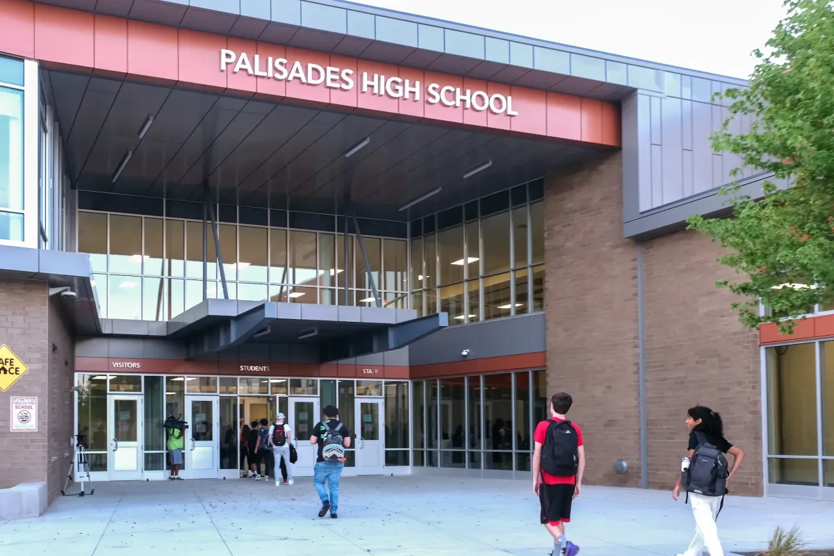 Main entrance of Palisades High School in southwest Charlotte with its modern campus, student entrance, and students arriving for the school day.