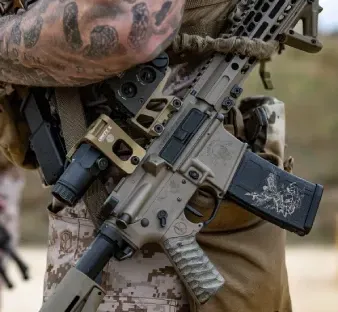 Three adult students receiving pistol fundamentals on a sunlit outdoor lane with a focused instructor demonstrating position and grip.