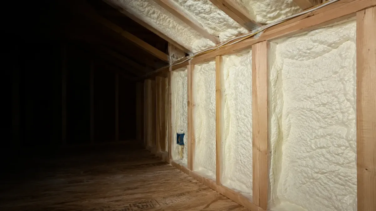 Professional spray foam insulation applied between wood framing and roof cavities in a Redmond Washington residential attic.